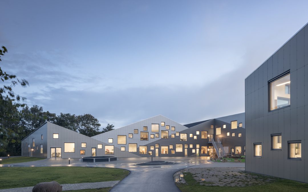A playfully punctured aluminum skin enlivens this Danish school