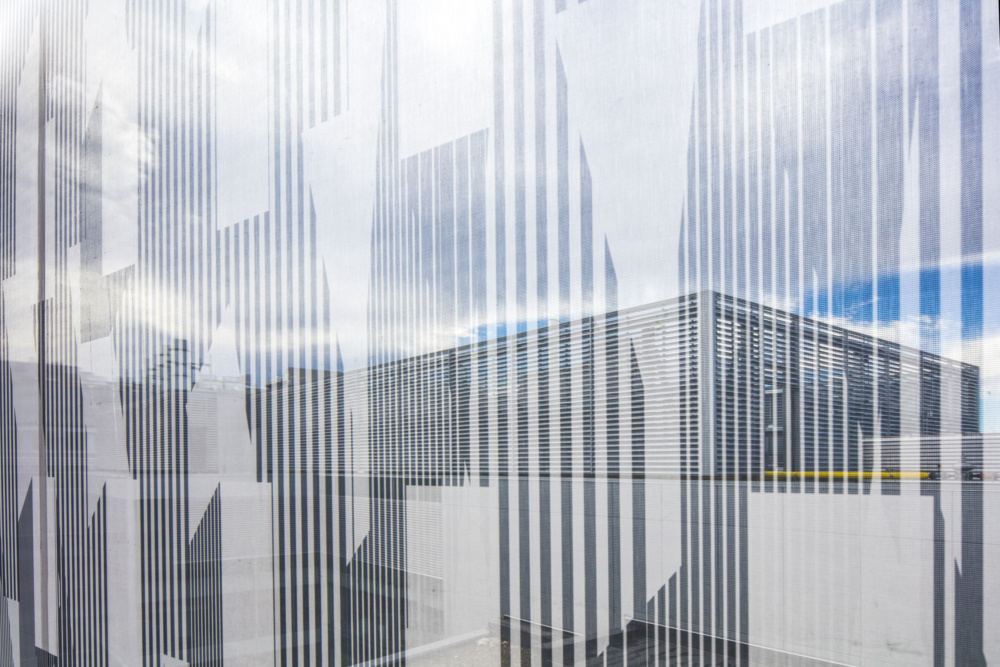 Details of a vertically banded metal mesh facade