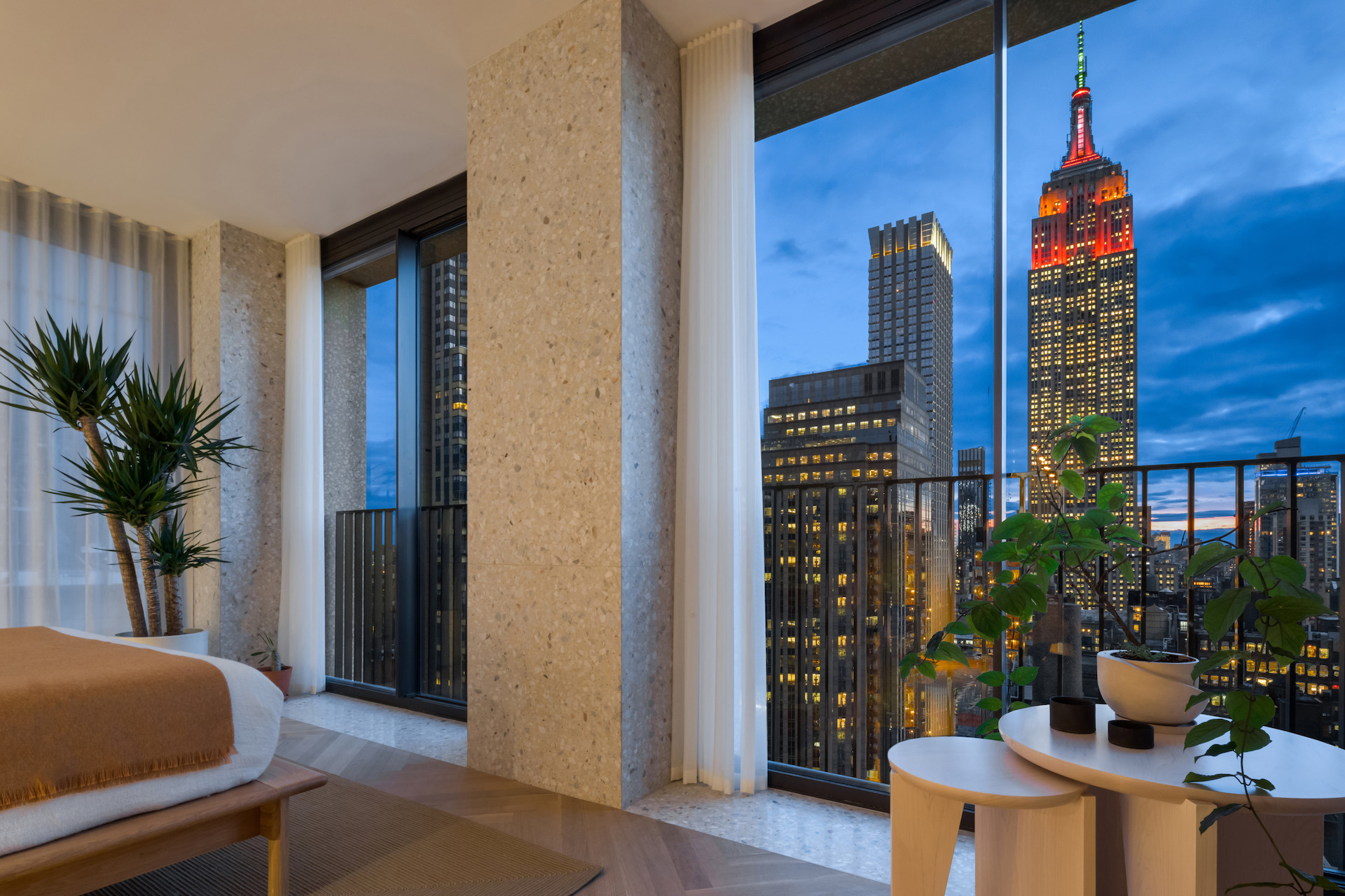 image looking out the window from the interior of the building. View shows Empire State building at night