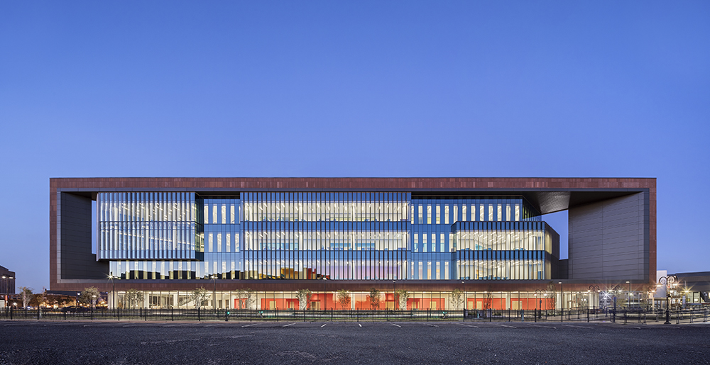Colored concrete and perforated fins keep this downtown school cool